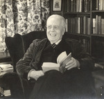 Photograph of Charles F. Wishart, Sitting With Book, Laughing